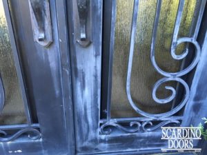Close up of repairing process for ornamental wrought iron door scrollwork
